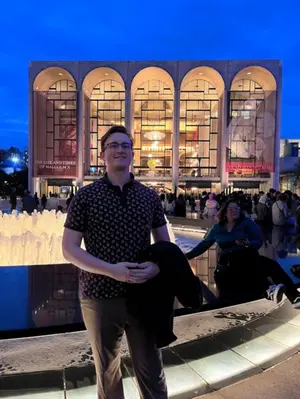Alex Walley, tenor, standing in front of the Metropolitan Opera House in New York City